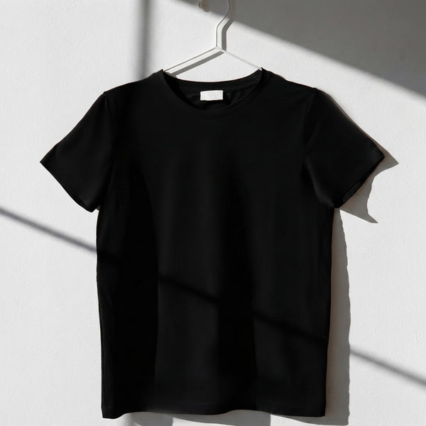 Close-up of a matte-textured graphic print on a black oversized cotton t-shirt with a focus on fabric quality.